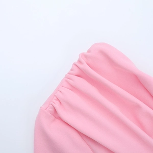 Détail du tissu froncé rose et des coutures élastiques sur la robe ajustée