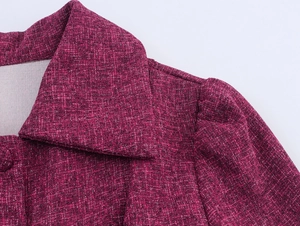 Detail of burgundy tweed jacket collar and pleated shoulder with textured fabric