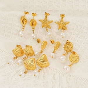 Gold ocean themed earrings set with starfish shell shapes and hanging white pearls