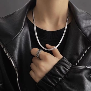 Silver stainless steel Cuban link necklace and matching ring on model in leather jacket