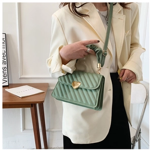 Close-up of mint green quilted PU leather handbag with a heart-shaped gold metal lock