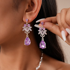 Detail of luxury teardrop purple gemstone earrings with silver floral filigree accents