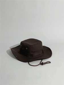 Detail view of brown boonie hat featuring metal ventilation holes and adjustable chin strap