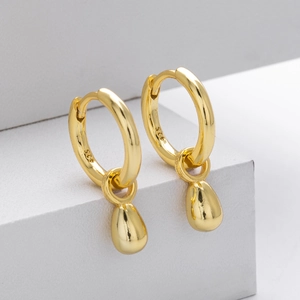Detailed macro view of gold-plated S925 sterling silver hoop earrings with water drop charms