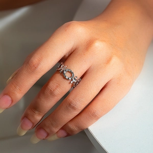 Detailed shot of hollow geometric chain ring with XO pattern on hand wearing minimalist style