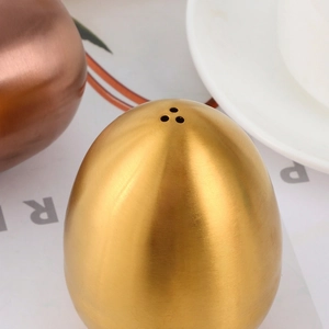 Egg-shaped brushed stainless steel seasoning shakers in gold and bronze finish