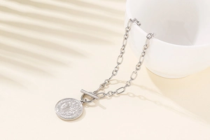 Detail of silver stainless steel necklace featuring a St. Benedict coin pendant and T-bar clasp