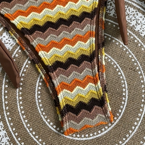 Close-up of crochet bikini bottoms featuring a colorful zigzag pattern and side ties