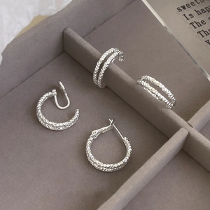 Detail of silver geometric textured earrings showing faceted surfaces in a velvet jewelry box