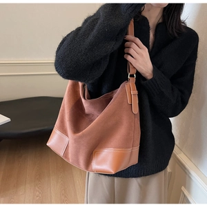 Close-up of vintage brown suede tote bag with leather straps on model's shoulder