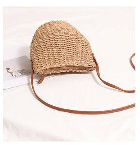Detailed top view of beige straw bucket bag with brown PU leather strap and zipper closure