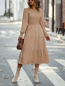 Détail d'une robe midi camel à manches longues avec texture plissée élégante et taille nouée