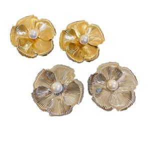Elegant metallic flower stud earrings with central white pearls in gold and silver finish