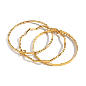 Detail shot of three-piece gold geometric wavy bangle set on a clean white background