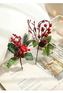Close-up of red Christmas berries with brown pine cones and green leaves in a basket