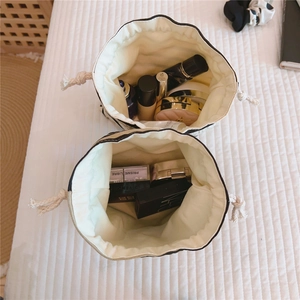 Detailed interior view of cream canvas drawstring pouch showing makeup storage capacity
