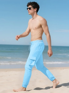 Men's sky blue cargo pants in waffle texture fabric shown in a beach setting