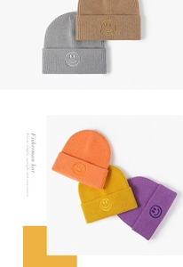 Nahaufnahme der Smiley-Stickerei auf verschiedenen bunten Strickmützen für Herbst und Winter