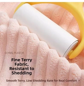 Lint roller removing debris from pink coral fleece towel surface showing fabric care