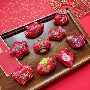 Detail of 9 Chinese New Year embroidered charms with lucky patterns on a wooden tray