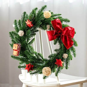 Christmas wreath with red velvet bow and pine needles on white chair decoration