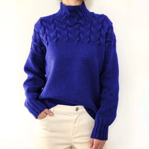 Detail shot of cable knit texture and turtleneck design on royal blue sweater