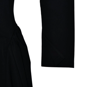 Détail de robe noire avec taille plissée et poignets fendus sur les manches élégantes