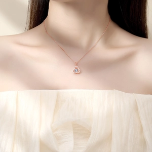Elegant rose gold dancing heart necklace with sparkling flower pendant on model neck