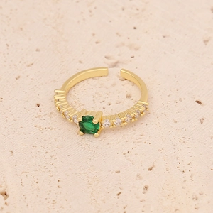 Macro detail of adjustable gold ring featuring a green zircon center and clear accents