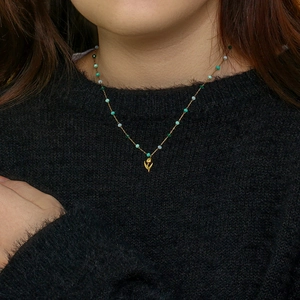 Collier tulipe avec perles colorées sur haut noir en tricot, porté par un mannequin