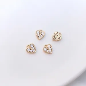 Detailed view of heart-shaped 14K gold plated charms with zircon and hollow pattern