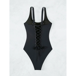 Detail of black one-piece swimsuit featuring adjustable straps and lace-up back design