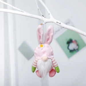 Gnomo pasquale di peluche rosa con orecchie da coniglio appeso a un ramo bianco