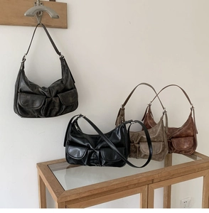 Detailed display of vintage baguette bags in multiple colors on a rustic wooden cabinet