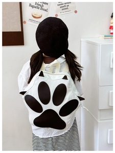 Rear view of child wearing cute black and white animal paw backpack with soft shoulder straps