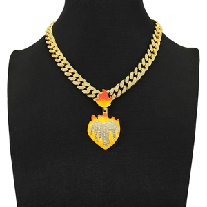 Detail of hip hop Cuban chain with a yellow and orange flame heart pendant on a bust