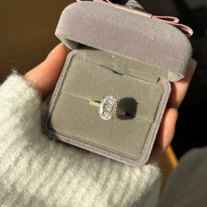 Macro shot of an oval cut crystal ring in gold setting placed in a grey velvet box
