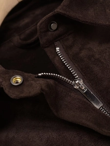 Close-up of silver metal zipper and snap buttons on dark brown faux suede jacket