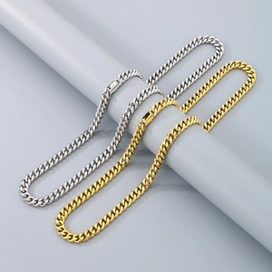 Detail of silver and gold stainless steel Cuban chains wrapped on a grey cylinder