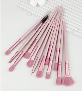 Close-up of pink professional makeup brush set on textured glass with pearls decor