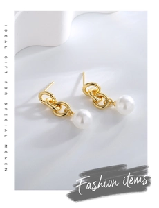 Detailed close-up of gold-plated triple interlocked rings with white pearl drops