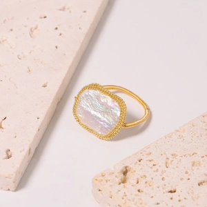 Elegante anello in oro con perla barocca su pietra beige con luce soffusa