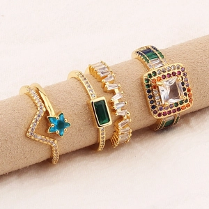 Three gold rings set with blue star, emerald green zircon, and rainbow gemstones