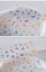 Detail of 3D laser rose and butterfly nail decals with iridescent pearls and stars