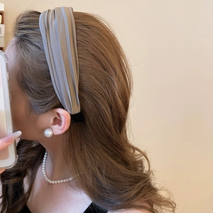 Élégant serre-tête large plissé taupe en satin montré de profil pour un look raffiné