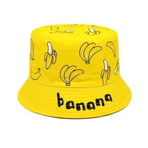 Detailed close-up of yellow canvas bucket hat with banana print and banana text logo