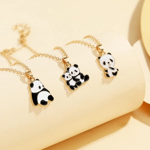 Dettaglio di tre ciondoli a forma di panda in smalto con catenine dorate in lega