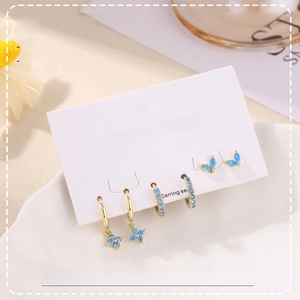 Detailed set of blue cubic zirconia hoop earrings and studs on a jewelry display card