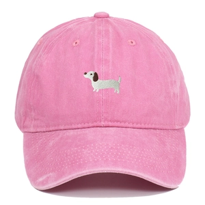 Close-up of pink washed cotton baseball cap featuring detailed puppy embroidery design
