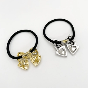 Detail of high-elasticity hair ties with textured gold and silver metal bow accents